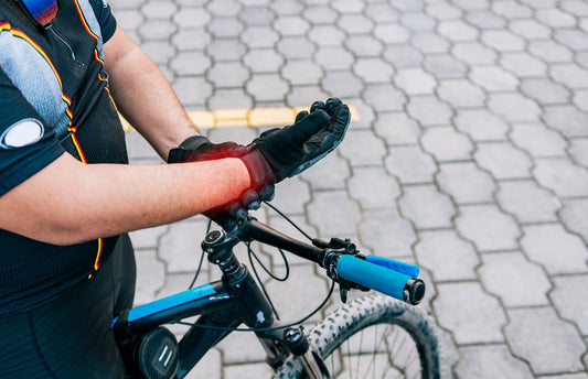 image of cyclist massaging wrist due to wrist pain
